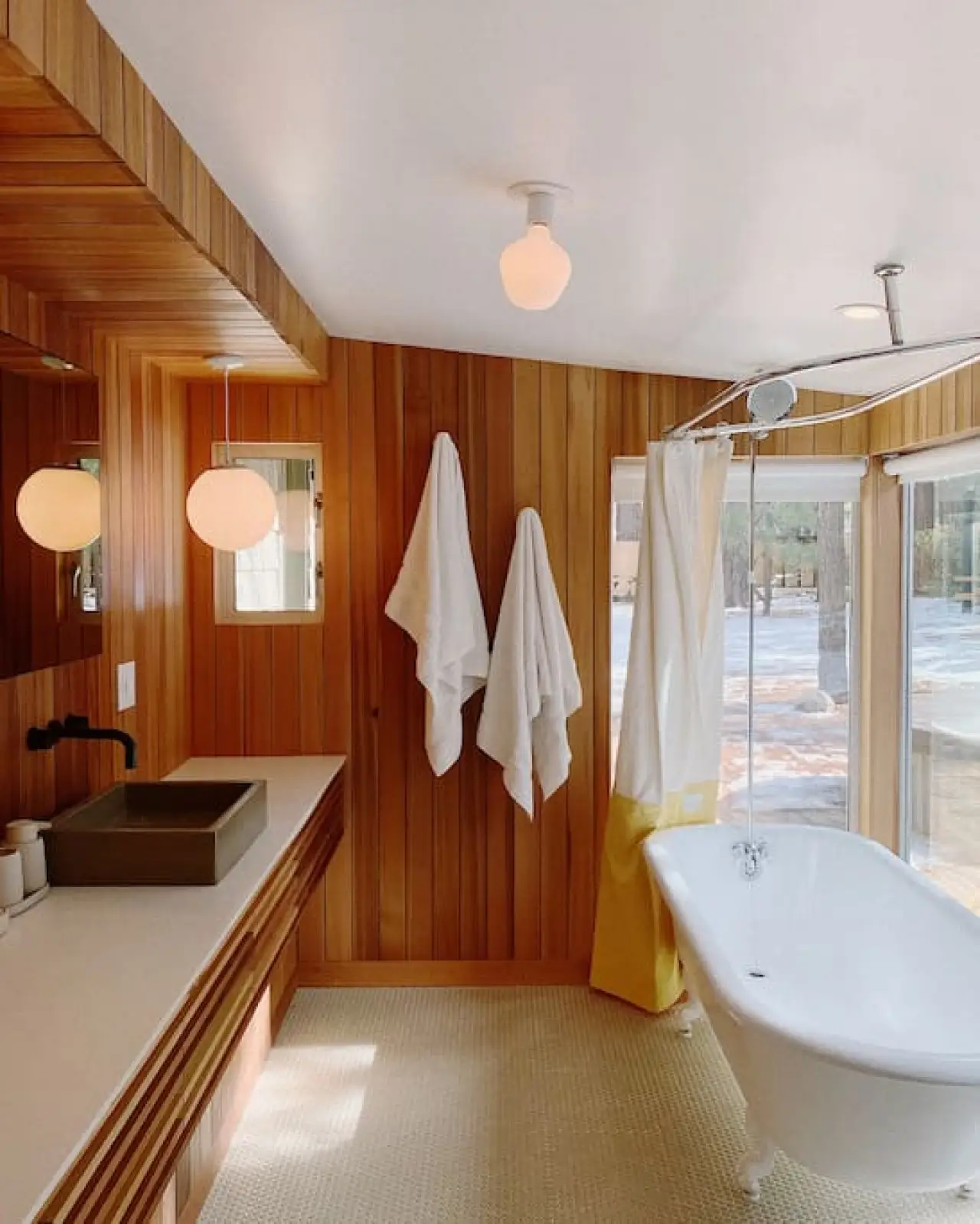 Colorado Lodge / C4 spa-bath master with clawfoot soaking tub and large forest-view windows at Colorado Lodge boutique lodge Big Bear Lake