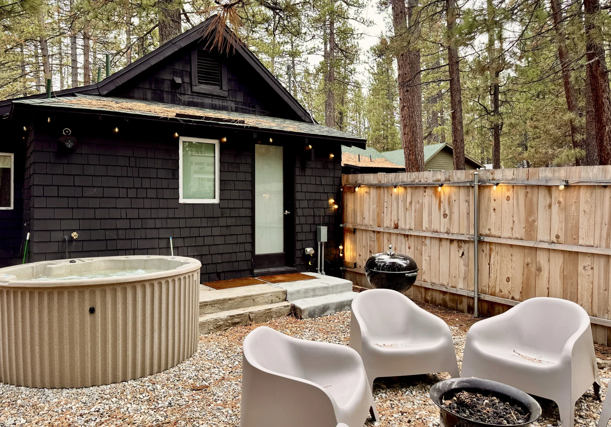 Private backyard hot tub inside the fenced yard at C6 The Place Beyond The Pines — pet-friendly Big Bear cabin at Colorado Lodge