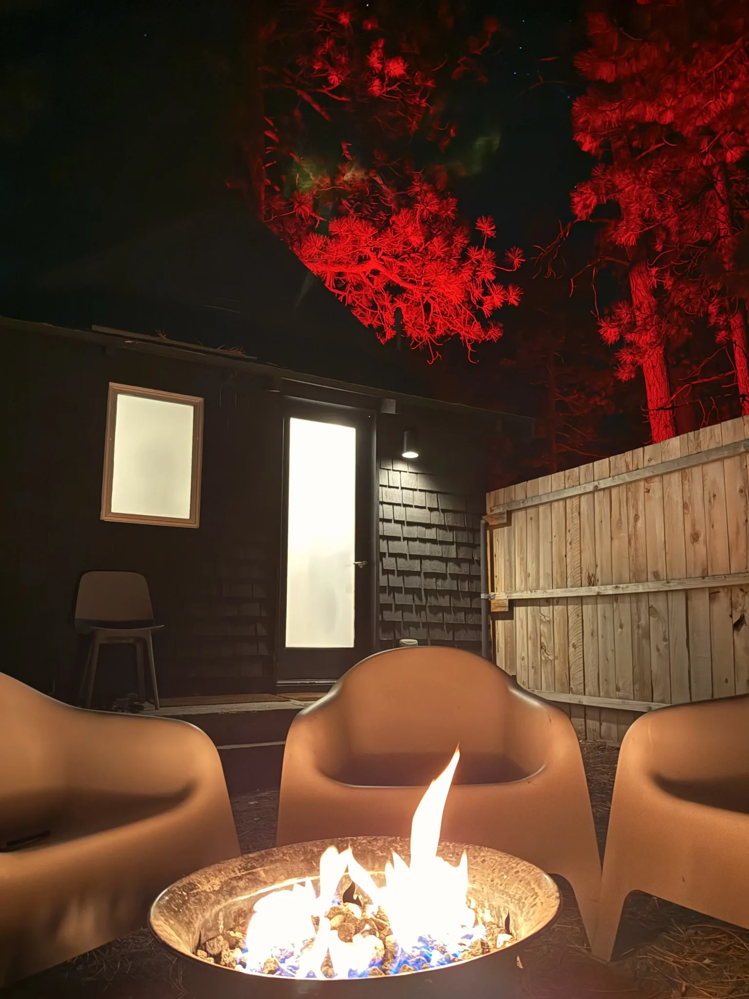 Campfire glowing outside a Colorado Lodge cabin at night — direct-booking savings on group stays in Big Bear
