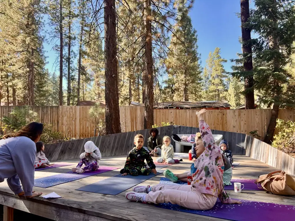 Large outdoor yoga deck surrounded by pine forest at Colorado Lodge in Big Bear Lake