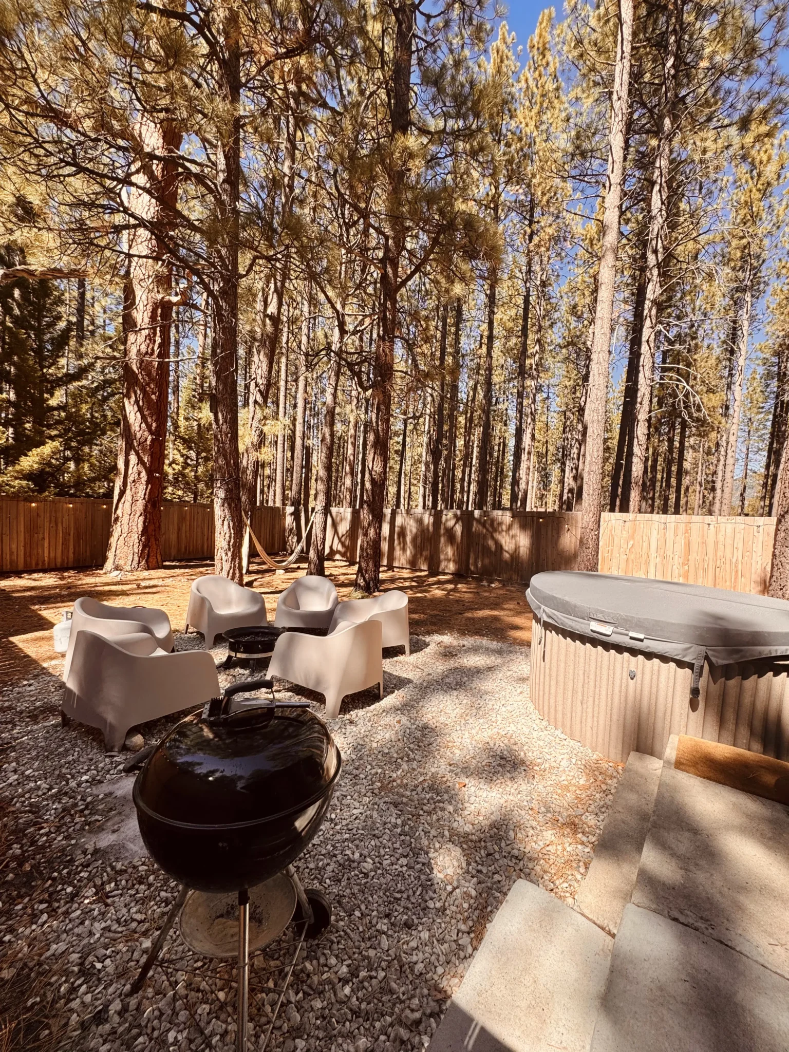 Private fenced backyard with hot tub and fire pit at C6 The Place Beyond The Pines, pet-friendly Big Bear cabin at Colorado Lodge