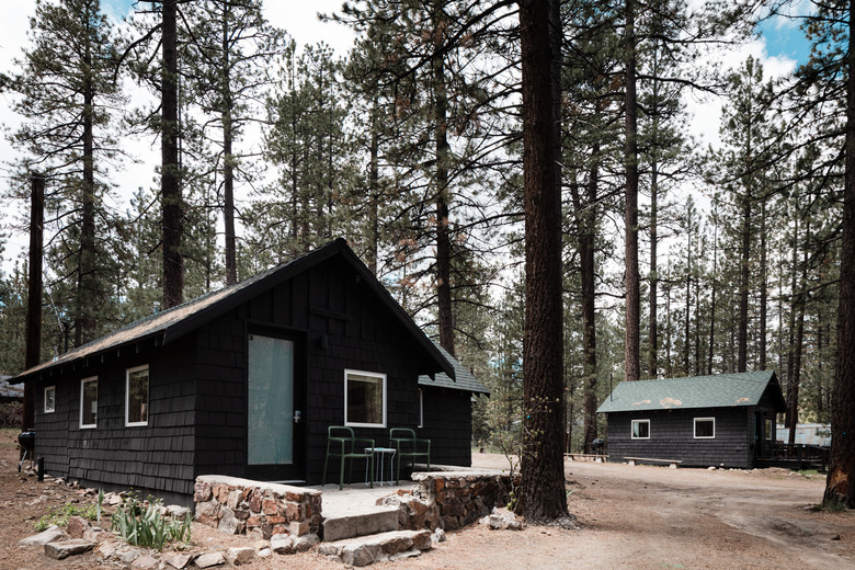 Black shingled cabin exterior surrounded by pine forest at Colorado Lodge in Big Bear Lake