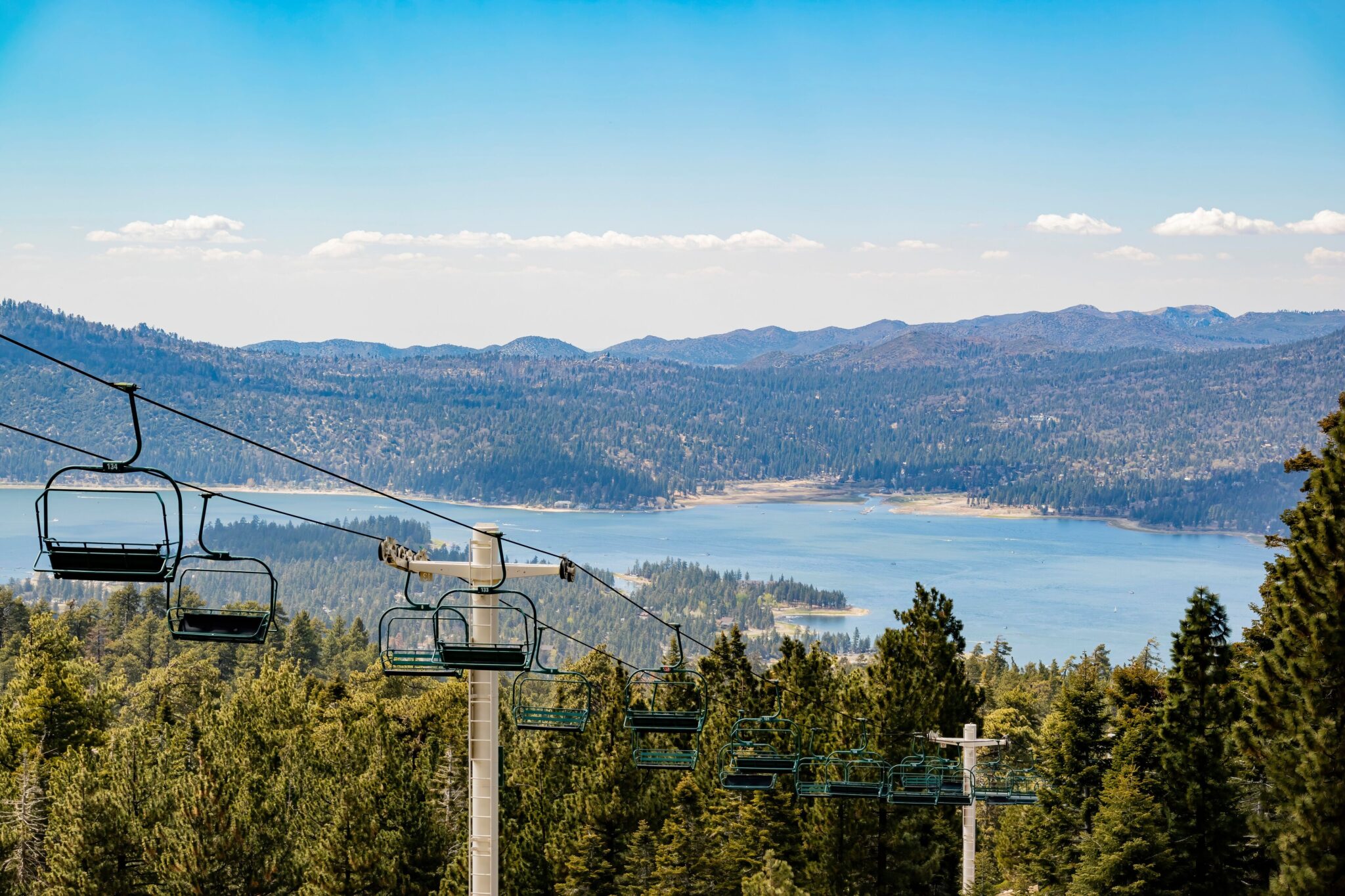 Scenic chairlift ride above pine forest overlooking Big Bear Lake and the San Bernardino Mountains